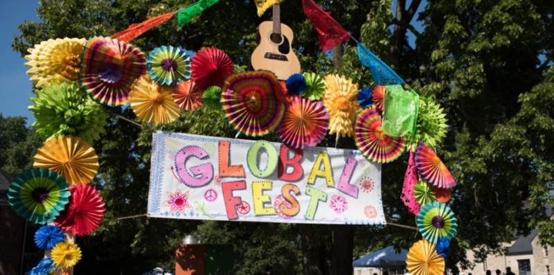 An archway with flowers and a sign saying "Global Fest"