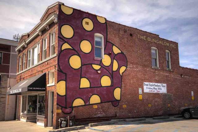 Red armchair with yellow polka dots on the side of a building in Broad Ripple